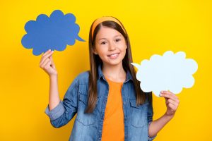 Girl holding up word bubble signs.