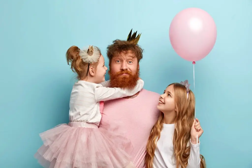 Photo of a dad and daughters dressed in pink ready to celebrate