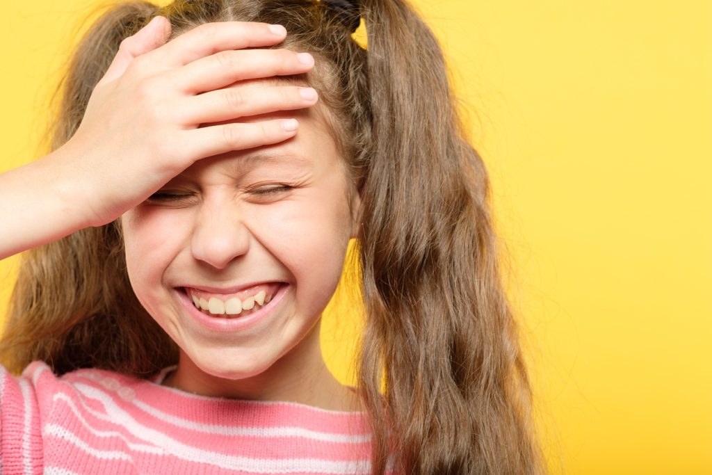 Girl laughing over an awkward moment or embarrassing situation.