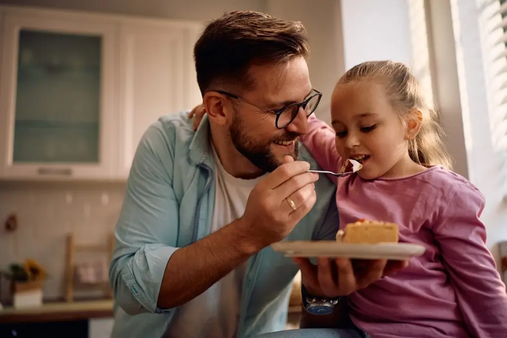 Father and daughter enjoying a piece of pie together.