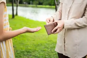 Photo of a teenage daughter asking her father for money.